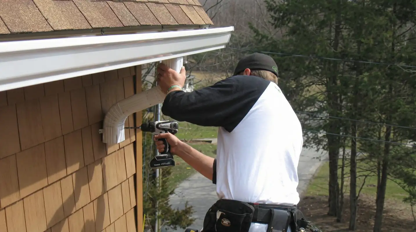Professional contractor installing tan vinyl siding panels on a residential home exterior in Lincoln, NE